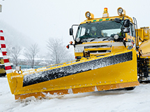 Snow plow in front of snow removal truck