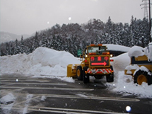 Parking lot removes snow with tractor excavator