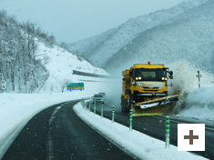 「道路を確保する除雪車」